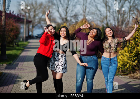 Groupe de quatre professionnels et de jolies filles de latino Equateur posés au niveau de la rue. Banque D'Images