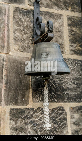 Une grande cloche en laiton hing sur un mur. Banque D'Images