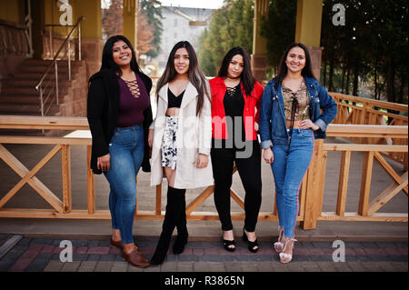 Groupe de quatre professionnels et de jolies filles de latino Equateur posés au niveau de la rue. Banque D'Images