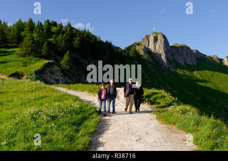 Randonneurs sur le sentier de la montagne Tegelberg près de Schwangau, en arrière-plan le sommet traverse sur les Alpes de Brandnerschrofen, Ammergau, Bavière, Allemagne Banque D'Images
