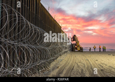 Le U.S. Customs and Border Patrol, agents installer des fils concertina en préparation de la caravane des migrants sur le terrain du parc d'État le 15 novembre 2018 à Imperial Beach, en Californie. Banque D'Images