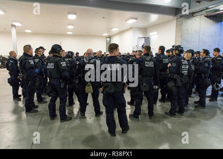 Le U.S. Customs and Border Patrol, agents se rassemblent pour un déploiement après toutes les voies vers les États-Unis du Mexique à la San Ysidro crossing ont été fermés dans le cadre de la préparation de la caravane des migrants, le 19 novembre 2018 à San Isidro, en Californie. Le passage à niveau est le plus achalandé port des terres le long de la frontière et a été fermée à la suite d'une fausse rumeur de la caravane des migrants à se précipiter de planification le point d'entrée. Banque D'Images