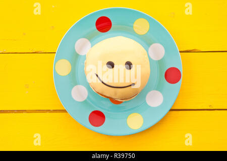 Donut avec smiley face Banque D'Images