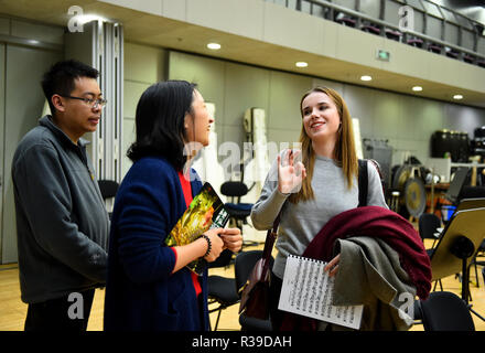 (181122) -- BEIJING, 22 novembre 2018 (Xinhua) -- Aleksandra Denga(R), de Pologne, de pourparlers avec ses collègues dans le National Centre for the Performing Arts à Beijing, capitale de la Chine, le 19 octobre 2018. Après son diplôme de l'Académie de musique de Gdansk en 2014, Aleksandra est venu en Chine pour travailler avec l'Orchestre symphonique de Guiyang comme violoniste dans le sud-ouest de la Chine, de la province du Guizhou, trois ans plus tard, après un court séjour en Espagne, il a décidé de revenir à nouveau en Chine, cette fois elle a trouvé un emploi au Centre National des Arts d'orchestre. "Au début c'était une aventure assez effrayant, Banque D'Images