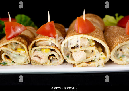 Crêpe au poulet avec une salade à l'intérieur avec fond noir isolé Banque D'Images