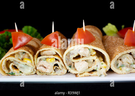 Crêpe au poulet avec une salade à l'intérieur avec fond noir isolé Banque D'Images