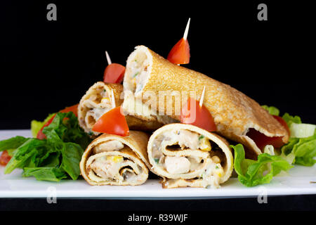 Crêpe au poulet avec une salade à l'intérieur avec fond noir isolé Banque D'Images