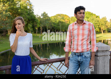 Couple multiethnique tout en pensant à la triste sur le pont de Banque D'Images