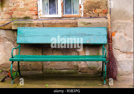 Vintage banc vert et de balais en face d'une vieille maison Banque D'Images