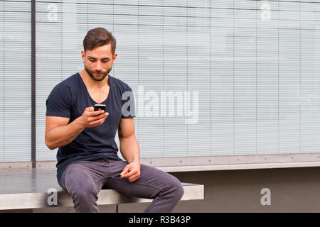 Les jeunes dans la ville rédige un message texte Banque D'Images