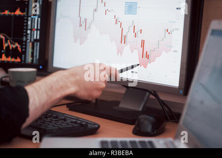 L'analyse des données. Close-up of young businessman sur les données présentées dans le tableau avec un stylo tout en travaillant dans creative office Banque D'Images