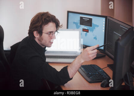 Programmeur d'hommes travaillant sur ordinateur de bureau avec de nombreux moniteurs à l'office de tourisme en compagnie de développement logiciel. Conception de site Web et programmation coding technologies Banque D'Images