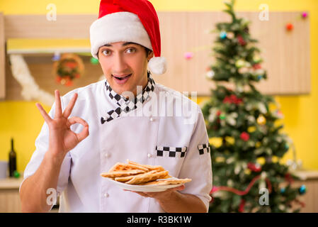 Jeune chef mari travaillant en cuisine à la veille de Noël Banque D'Images