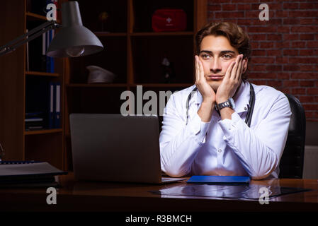 Beau jeune médecin travaillant la nuit à l'hôpital Banque D'Images