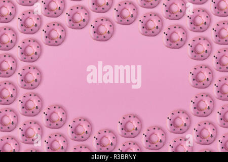 Beaucoup de donuts avec un glaçage sur un fond rose with copy space Banque D'Images