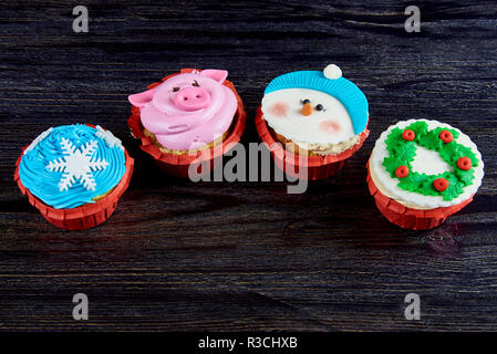 Divers Noël cupcakes sur une surface en bois sombre. Banque D'Images