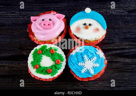 Divers Noël cupcakes sur une surface en bois sombre. Banque D'Images