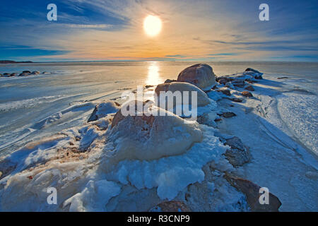 Canada, Manitoba, Winnipeg. Coucher du soleil sur le lac Winnipeg la glace au printemps. Banque D'Images