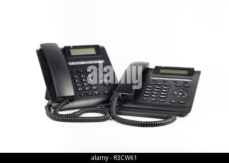 Deux téléphones IP noir sur fond blanc, close-up. Banque D'Images