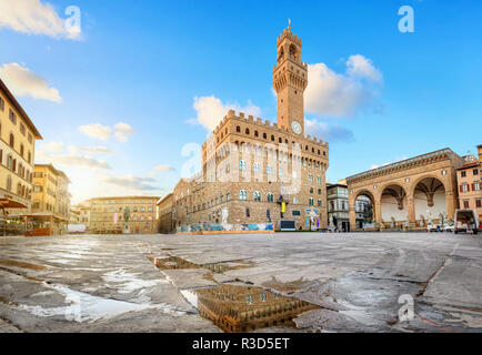 Florence, Italie. Vue sur la Piazza della Signoria avec le Palazzo Vecchio se reflétant dans une flaque d'eau au lever du soleil Banque D'Images