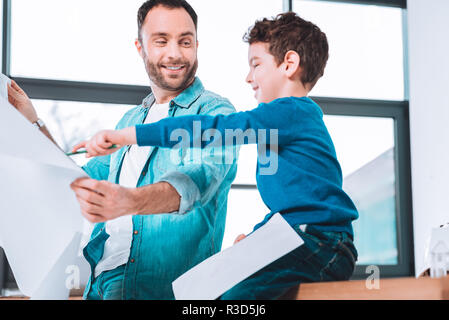 Le Fils et le père. Enfant ambitieux, pointant sur l'écrit tout en travaillant avec le père Banque D'Images