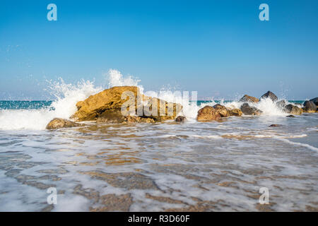 Paysage de l'île grecque représentant vagues se briser vers le bas, une formation de rochers à la rive. Banque D'Images