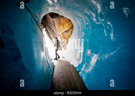 Glaciolog David Volken à l'embouchure du glacier du Rhône. D'immenses draps avec des couvertures en polaire qui couvrent un tunnel de glace à l'embouchure du glacier du Rhône en Suisse. Après un hiver avec des quantités records de neige, la plus grande partie a disparu lorsque cet imae a été pris le 14 juillet 2018, exposant la glace plus sombre. Alors que la neige est un brillant réflecteur de l'énergie du soleil, la glace plus sombre absorbe l'énergie, accélérant ainsi la fonte du glacier. La couleur et l'obscurité de la glace du glacier varient partout dans le monde, selon l'accumulation de pollution, l'âge de la glace, les particules récupérées par la glace et par Banque D'Images