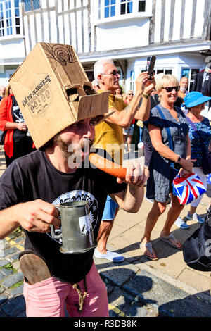 Faversham Hop Festival. Fan du groupe de rock français, sur les docks, chanter, danser avec boîte en carton sur la tête et tenant comme saucisse micro. Banque D'Images