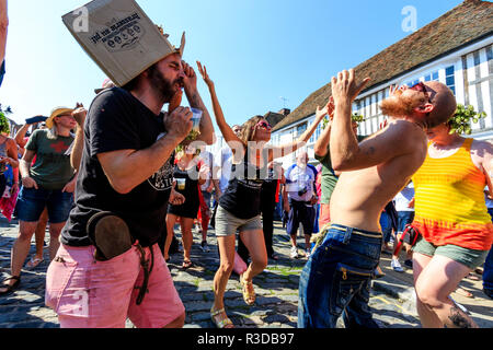 Faversham Hop Festival. Fan du groupe de rock français, sur les docks, chanter, danser avec boîte en carton sur la tête et tenant comme saucisse micro. Banque D'Images