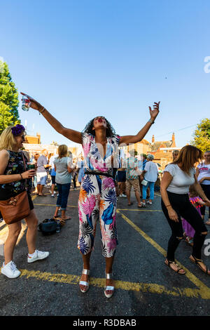 Festival 2018 Hop Faversham. Les gens, le public, en concert au parking. Femme debout en face de spectateur avec les bras tendus et la tête rejetée en arrière. Banque D'Images