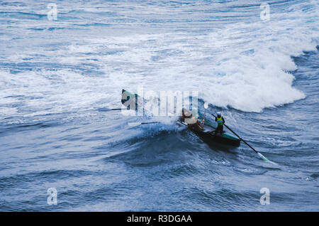 Des hommes courageux se fracassent dans une vague à Piha Beach, en Nouvelle-Zélande Banque D'Images