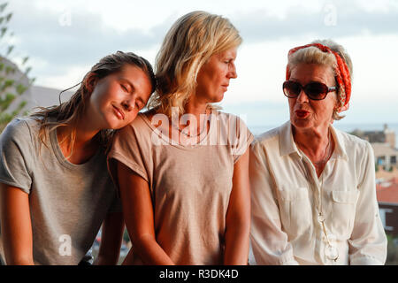 Trois générations de femmes attrayants d'une famille ensemble sur la terrasse d'été. Authentique, sans fioritures, unplugged. Banque D'Images