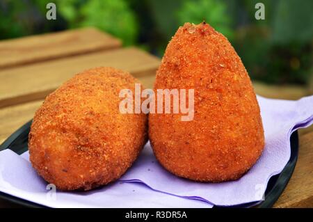 Un couple d'arancini, rue typiquement sicilienne à base de riz Banque D'Images