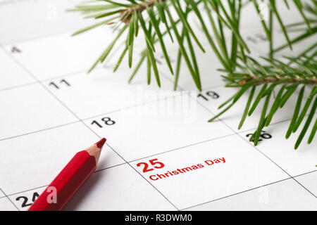 Stylo rouge a fait à jour de Noël texte sur fond de calendrier Banque D'Images