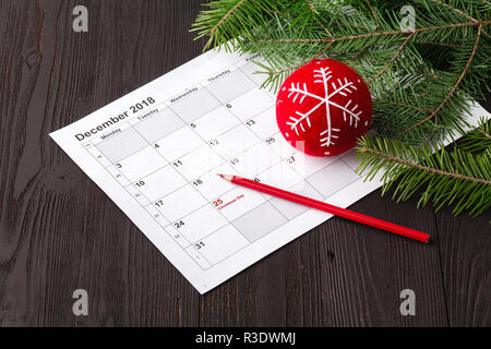 Stylo rouge a fait à jour de Noël texte sur fond de calendrier Banque D'Images