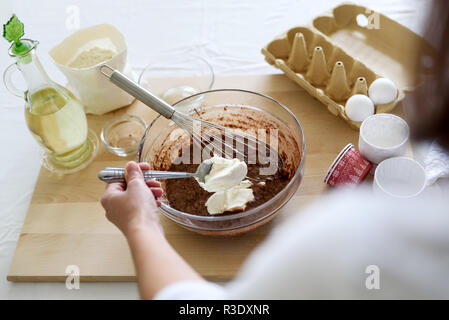 La cuisson des muffins au chocolat de Noël. Le mélange des ingrédients pour les brownies, gâteaux, crêpes. Femme mains préparation Banque D'Images