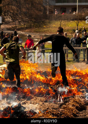 Les braves sautent sur le feu pendant la course d'obstacles Tough Viking à Slottsskogen, Göteborg, Suède Banque D'Images