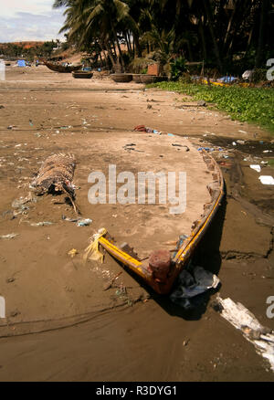 Un bateau abandonné couvert de sable sur une plage au Vietnam Banque D'Images