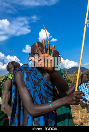Un guerrier de la tribu Suri refusant la photographie durant un combat au bâton donga rituel, vallée de l'Omo, Kibish, Ethiopie Banque D'Images