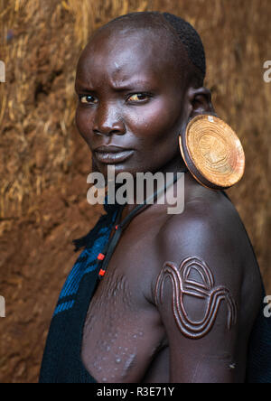 Portrait d'une femme de la tribu suri avec lobes élargie et d'énormes boucles d'oreilles, vallée de l'Omo, Kibish, Ethiopie Banque D'Images