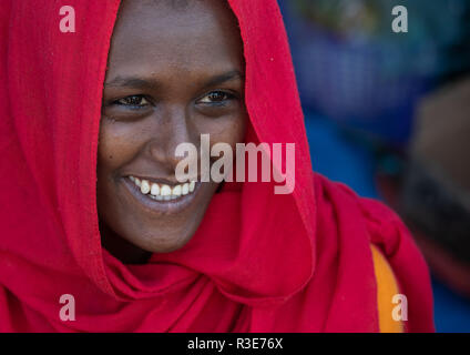 Smiling teenage girl oromo portant un voile rouge, région d'Amhara, Senbete, Ethiopie Banque D'Images