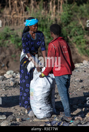 Ethiopan emballage dans des sacs de charbon de personnes sur un marché, région d'Amhara, Senbete, Ethiopie Banque D'Images