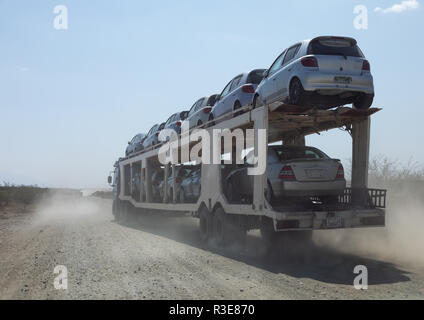 Camion transportant des voitures neuves en provenance de port de Djibouti sur une route poussiéreuse, Oromia, affleurante, Ethiopie Banque D'Images