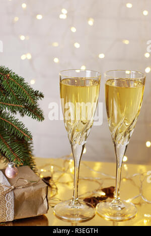 Deux verres de champagne sont sur la table à côté de la Noël et Nouvel An des cadeaux sous l'arbre de Noël. Banque D'Images