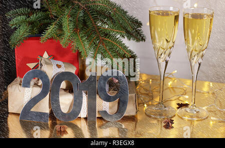 Deux verres de champagne sont sur la table à côté des cadeaux pour Noël et la nouvelle année 2019 sous l'arbre de Noël. Banque D'Images