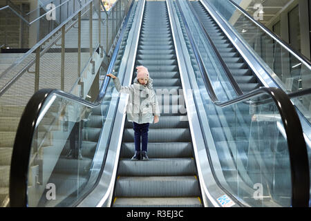 À partir de ci-dessous shot of Girl standing on déménagement escaliers dans terminal. Banque D'Images