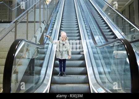 À partir de ci-dessous shot of Girl standing on déménagement escaliers dans terminal. Banque D'Images