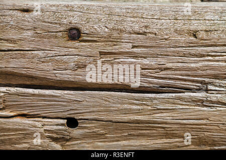 La texture de la vieille planche de bois avec des rainures profondes, s'est évanoui dans la pluie et le soleil à l'extérieur. Trace d'un clou rouillé dans le conseil Banque D'Images