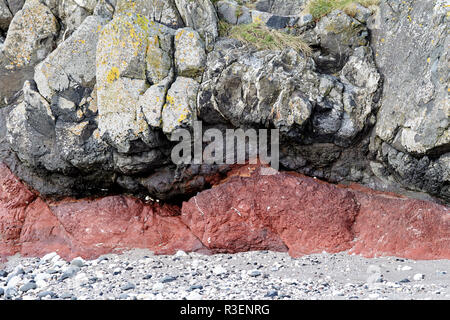 Couches de couches de roches basaltiques downfaulted y compris red band formé de cendres enterrées Ballintoy le comté d'Antrim en Irlande du Nord Banque D'Images