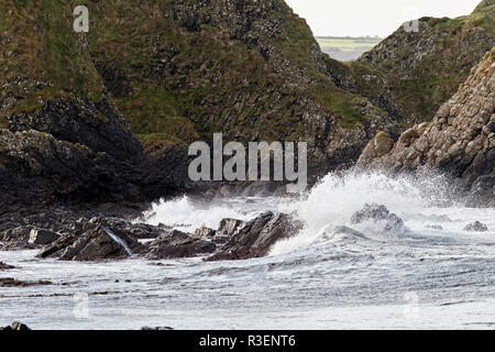 Vagues plus downfaulted les couches de roche basaltique partie du comté d'Antrim Ballintoy côte au comté d'Antrim en Irlande du Nord Banque D'Images